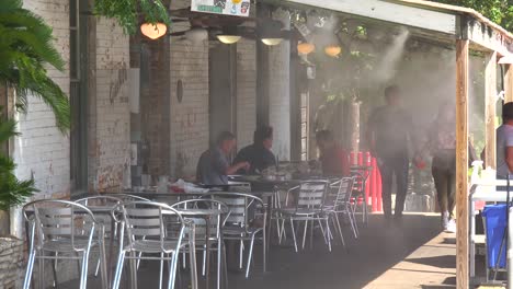 In-Einem-Restaurant-In-Austin,-Texas,-Halten-Sich-Die-Gäste-In-Der-Sommerhitze-Unter-Wasser,-Das-Ventilatoren-Bläst,-Kühl