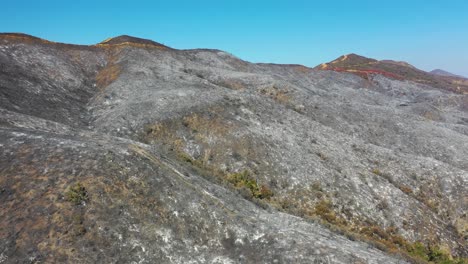 Colinas-Rojas-Y-Negras-En-El-Sur-De-California-Cubiertas-De-Ceniza-Y-Retardante-De-Fuego-Después-De-Un-Incendio-Forestal