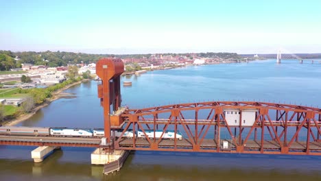 Antena-De-Un-Tren-De-Pasajeros-Amtrak-Cruza-El-Río-Mississippi-En-Un-Puente-Levadizo-De-Acero-Cerca-De-Burlington,-Iowa