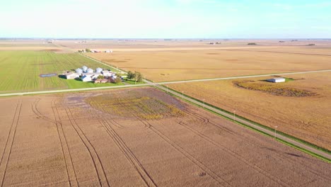 Gute-Antenne-über-Eine-Kreuzung-Zweier-Straßen-Mitten-Im-Nirgendwo-Riesiges-Flaches-Ackerland-Und-Felder-In-Iowa,-Illinois-Oder-Indiana