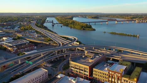 Antena-Sobre-El-Intercambio-De-Autopistas-En-Louisville,-Kentucky-Con-El-Fondo-Del-Río-Ohio-Sugiere-Infraestructura