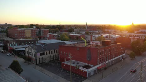 Aerial-Over-Inflatable-Tube-Man-Blowing-On-The-Roof-Of-A-Building-At-Sunset