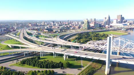 Aerial-Over-Freeway-Interchange-In-Louisville,-Kentucky-With-Ohio-River-Background-Suggests-Infrastructure