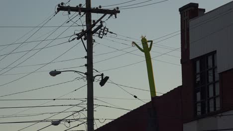 Funny-Or-Humorous-Shot-Of-Inflatable-Tube-Man-Blowing-On-The-Rooftop-Of-A-Building