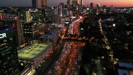 Tilting-Aerial-Shot-Of-Atlanta,-Georgia-Freeway-And-Downtown-Skyline-At-Dusk,-Sunset-Or-Night