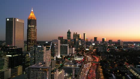 Schwenkende-Luftaufnahme-Von-Atlanta,-Georgia-Freeway-Und-Der-Skyline-Der-Innenstadt-Bei-Dämmerung,-Sonnenuntergang-Oder-Nachts