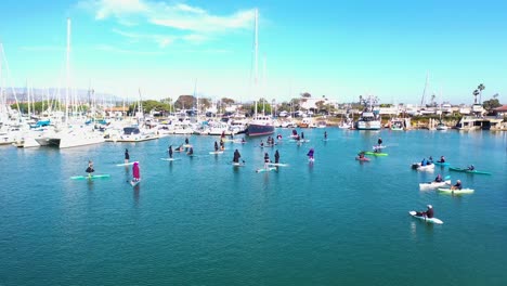 Aerial-Witches-Paddle-On-Surfboards-And-Paddleboards-To-Celebrate-Halloween-In-Ventura-Harbor,-California