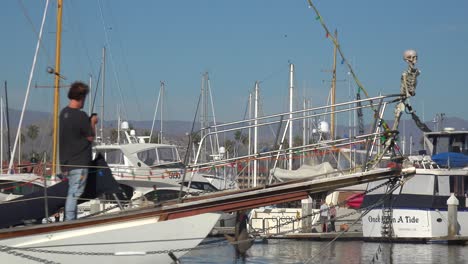 A-Halloween-Party-Boat-With-A-Skeleton-On-The-Bow-And-Large-Orange-Pumpkin-On-Stern-Moves-Through-Ventura-Harbor,-California