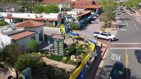 Ukrainische-Antikriegs-Demonstranten-Aus-Der-Luft-Zeigen-Eine-Lange-Fahne-Auf-Einem-Generischen-Parkplatz,-Um-Gegen-Die-Russische-Invasion-In-Der-Ukraine-Zu-Protestieren