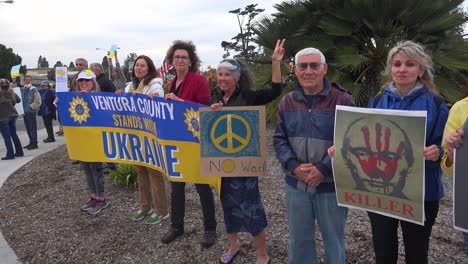 Protesters-Gather-To-Hold-Signs-In-Support-Of-Ukraine-Following-Russia-Invasion,-With-One-Sign-Identifying-Putin-As-A-Killer