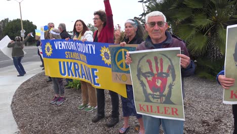 Protesters-Gather-To-Hold-Signs-In-Support-Of-Ukraine-Following-Russia-Invasion,-With-One-Sign-Identifying-Putin-As-A-Killer