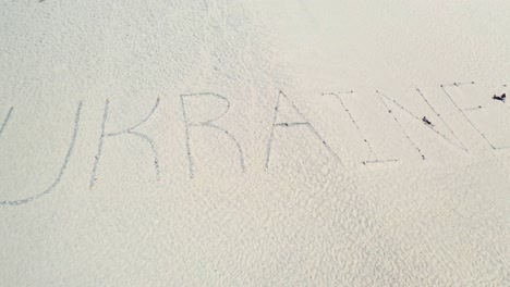 Aerial-Of-The-Word-Ukraine-Written-On-Sand-Dunes-At-Pt-Magu-Near-Malibu,-California