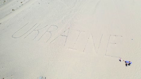 Aerial-Of-The-Word-Ukraine-Written-On-Sand-Dunes-At-Pt-Magu-Near-Malibu,-California