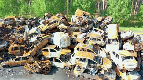 Rising-Aerial-Of-Wrecked-And-Burned-Cars-In-The-Car-Cemetery-Sitting-In-A-Pile-Many-With-Bullet-Holes-From-Russian-Aggression,-Irpin-Ukraine