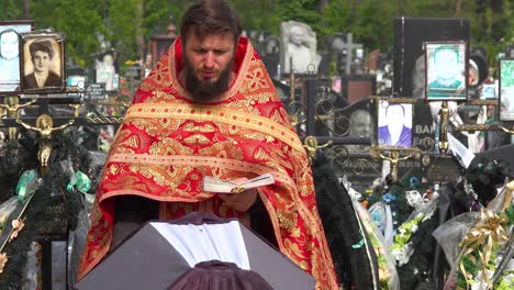 Un-Sacerdote-Ortodoxo-Ucraniano-Administra-Los-últimos-Ritos-A-Una-Víctima-De-La-Guerra-En-Ucrania,-En-El-Cementerio-De-Irpin-(Kyiv)