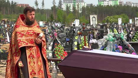 Un-Sacerdote-Ortodoxo-Ucraniano-Administra-Los-últimos-Ritos-A-Una-Víctima-De-La-Guerra-En-Ucrania,-En-El-Cementerio-De-Irpin-(Kyiv)