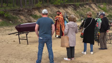 Un-Sacerdote-Ortodoxo-Ucraniano-Administra-Los-últimos-Ritos-A-Una-Víctima-De-La-Guerra-En-Ucrania,-En-El-Cementerio-De-Irpin-(Kyiv)