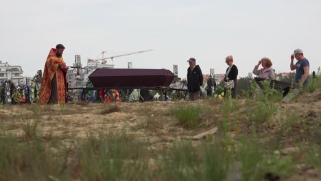 Un-Sacerdote-Ortodoxo-Ucraniano-Administra-Los-últimos-Ritos-A-Una-Víctima-De-La-Guerra-En-Ucrania,-En-El-Cementerio-De-Irpin-(Kyiv)