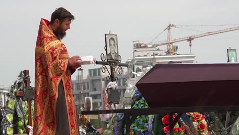 A-Ukrainian-Orthodox-Priest-Administers-Last-Rites-To-A-Victim-Of-The-War-In-Ukraine,-In-The-Irpin-(Kyiv)-Cemetery