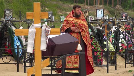 Un-Sacerdote-Ortodoxo-Ucraniano-Administra-Los-últimos-Ritos-A-Una-Víctima-De-La-Guerra-En-Ucrania,-En-El-Cementerio-De-Irpin-(Kyiv)