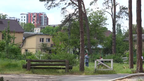 A-Couple-Talks-In-A-Park-Amongst-Devastation-During-The-Ukraine-War-In-Irpin