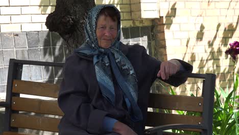 An-Old-Babushka-Woman-Contemplates-Her-Fate-On-The-Streets-Of-Bucha-Ukraine-Following-The-Russian-Invasion