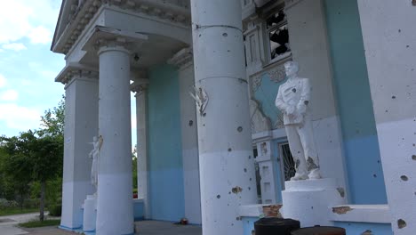 Statues-Stand-In-Front-Of-The-Devastated-Exterior-Of-The-Bucha-Concert-Music-Hall-In-Bucha,-Ukraine-Following-The-Russian-Invasion