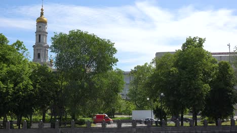 Dormition-Cathedral-Church-Gold-Domes-In-Central-Kharkiv,-Ukraine-With-Street-Traffic-Foreground