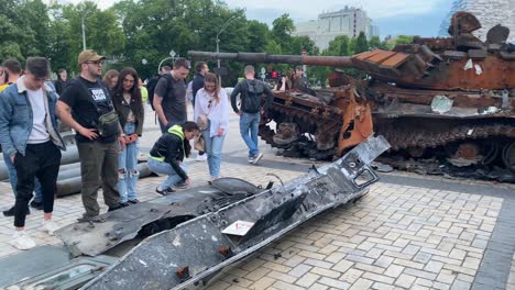 Turistas-Y-Ucranianos-Admiran-Los-Restos-Del-Equipo-De-Guerra-Ruso-Capturado-En-Una-Plaza-Central-En-El-Centro-De-Kiev,-Ucrania