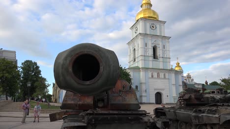 Tourists-And-Ukrainians-Admire-The-Wreckage-Of-Captured-Russian-War-Equipment-On-A-Central-Square-In-Downtown-Kyiv-Kiev-Ukraine-With-St-Michael'S-Gold-Domed-Cathedral-Background