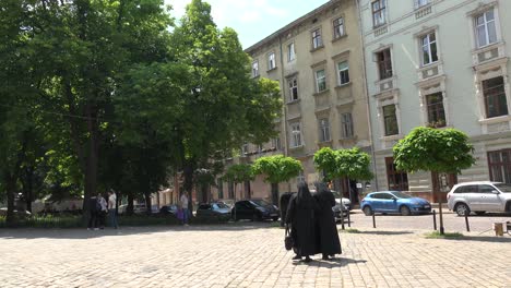 Two-Catholic-Nuns-Walk-Through-A-Courtyard-In-Lviv,-Ukraine