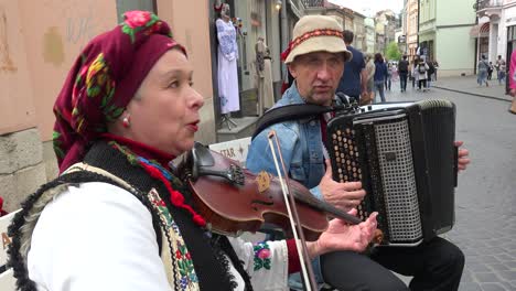 Dúo-Musical-Tradicional-Toca-Violín-Y-Acordeón-En-La-Calle-En-El-Casco-Antiguo-De-Lviv,-Ucrania