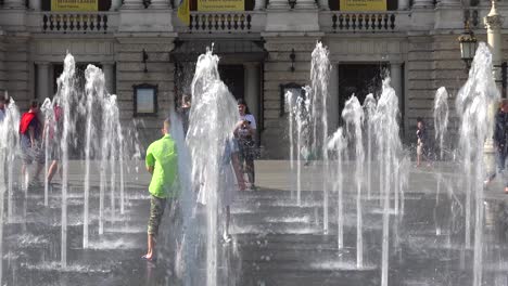 Los-Niños-Juegan-En-Las-Fuentes-Danzantes-Fuera-De-La-Majestuosa-ópera-En-El-Centro-De-Lviv,-Ucrania