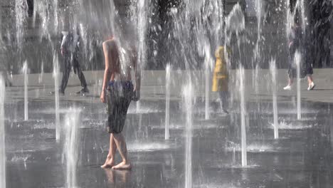 Children-Play-In-The-Dancing-Fountains-Outside-The-Majestic-Opera-House-In-Central-Lviv,-Ukraine