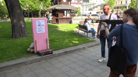 Menschen-Schießen-Mit-Einem-Luftgewehr-Auf-Das-Bild-Von-Wladmir-Putin-Auf-Der-Straße-Im-Zentrum-Von-Lemberg,-Ukraine