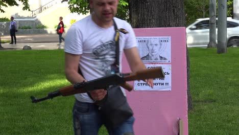 People-Shoot-An-Air-Rifle-At-The-Image-Of-Vladmir-Putin-On-The-Street-In-Central-Lviv,-Ukraine