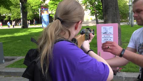 People-Shoot-An-Air-Rifle-At-The-Image-Of-Vladmir-Putin-On-The-Street-In-Central-Lviv,-Ukraine