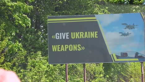 A-Road-Sign-Billboard-Along-A-Highway-In-Ukraine-Says-""Give-Ukraine-Weapons""-For-Their-War-Effort