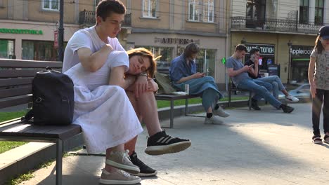 Ukrainian-Lovers-Sit-On-A-Park-Bench-In-The-Sun-In-Central-Lviv,-Ukraine