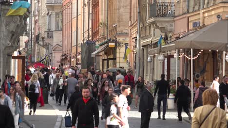 Good-Establishing-Shot-Of-Crowds-In-Old-City-Lviv,-Ukraine,-With-Cafe,-Street,-Old-Buildings-And-Pedestrians