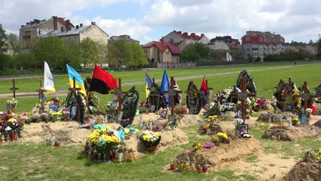 Freshly-Dug-Graves-In-Open-Fields-Near-Apartment-Blocks-In-Lviv,-Ukraine-Mark-The-Resting-Place-Of-Ukrainian-Soldiers