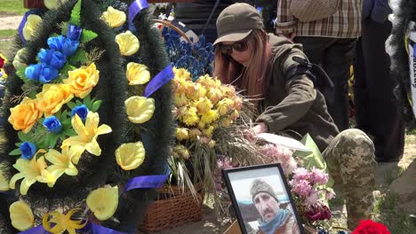 A-Ukrainian-Woman-In-Camouflage-Maintains-A-Grave-With-Her-Family-At-A-War-Cemetery-In-Lviv