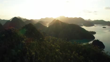 Excelente-Toma-Aérea-Del-Sol-Asomándose-Sobre-Las-Islas-Wayag,-Raja-Ampat,-Indonesia