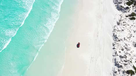 Excelente-Toma-Aérea-De-Un-Camión-Que-Circula-Por-Las-Arenas-Blancas-De-La-Bahía-De-Wharton-Mientras-El-Agua-Azul-Clara-Baña-La-Costa-En-Esperance,-Australia