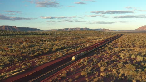 Excelente-Toma-Aérea-De-Un-Tren-De-Carbón-Que-Viaja-A-Través-De-Tom-Price,-Australia