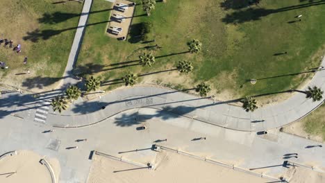 Excelente-Vista-De-Pájaro-De-Personas-En-Bicicleta-A-Lo-Largo-De-Una-Acera-Curva-En-Santa-Mónica,-California