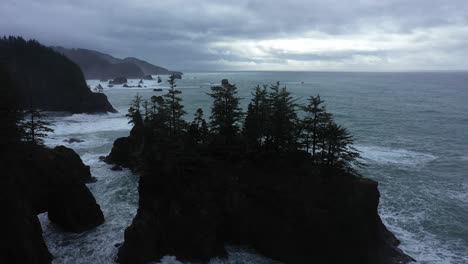 Excellent-Aerial-Shot-Of-Pine-Trees-On-Large-Rocks-Off-The-Coast-Of-Oregon-On-An-Overcast-Day