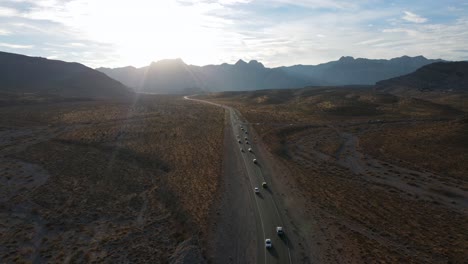 Excelente-Vista-Aérea-De-Autos-Conduciendo-Por-Una-Autopista-En-La-Región-De-Rocas-Rojas-De-Nevada