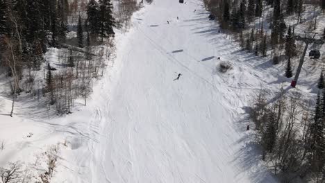 Excelente-Vista-Aérea-De-Personas-Esquiando-Y-Practicando-Snowboard-En-Steamboat-Springs,-Colorado