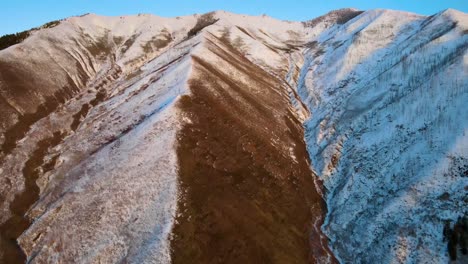 Excelente-Toma-Aérea-De-Una-Cadena-Montañosa-Marrón-E-Invernal